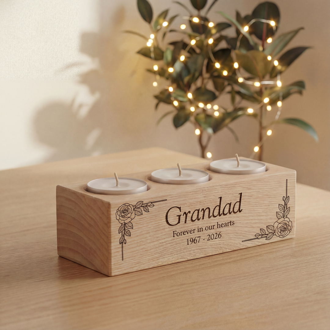 Wooden candle holder with engraved text on a table with a plant in the background